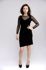 Horizontal Portrait of a pretty slim beautiful fashionable adult girl with beautiful brunette hair in a black dress. It should be in full growth, talking showing different poses and emotions