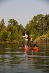 Fototapeta na wymiar Young Man Kayak Fishing at Sunrise in Canada