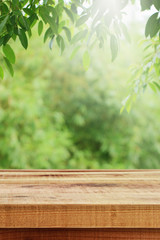 Wooden table and blurred green leaf nature in garden background. 