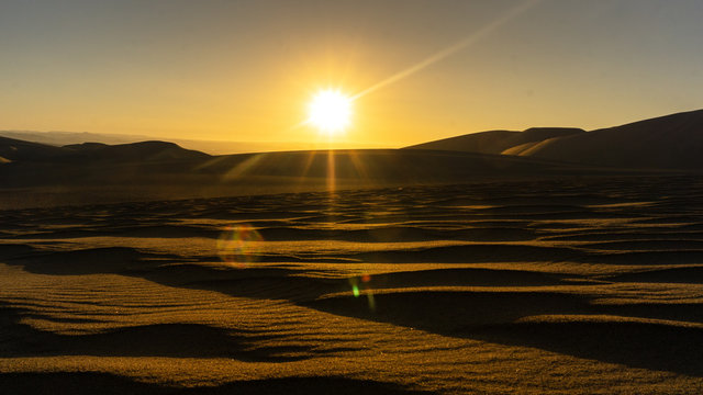Sol en el desierto al atardecer sobre dunas 