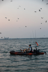 Naklejka premium Young Man Kayak Fishing at Sunrise in Canada