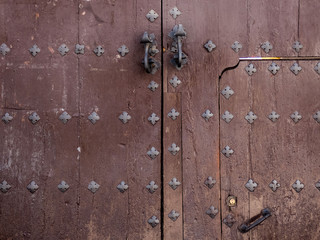 Fototapeta premium Old wooden gate fixed with brass rivets in Cordoba, Andalusia, Spain.