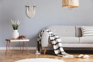 Fotobehang Boho Design bohemian composition of living room interior with gray sofa, wooden coffee table, beige macrame, rattan lamp ,plants, plaid and elegant accessories. Stylish home decor. Template.  © FollowTheFlow