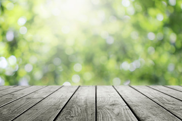 Blurred abstract green bokeh and wooden table background.