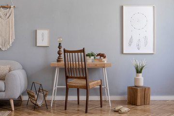 Stylish and design home interior of living room with gray sofa, wooden cube and desk, books, plants, mock up poster frame, macrame and elegant accessories. Stylish home decor. Template.  