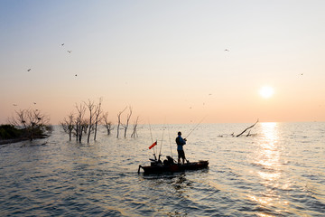 Fototapeta premium Young Man Kayak Fishing at Sunrise in Canada