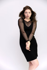 Horizontal Portrait of a pretty slim beautiful fashionable adult girl with beautiful brunette hair in a black dress. It should be in full growth, talking showing different poses and emotions