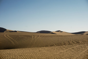 Vista del desierto por la mañana con marcas de vehículos