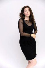 Horizontal Portrait of a pretty slim beautiful fashionable adult girl with beautiful brunette hair in a black dress. It should be in full growth, talking showing different poses and emotions