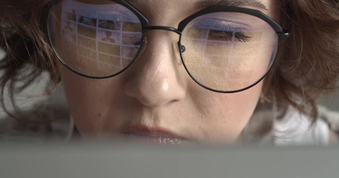 Attractive Young Hipster Girl Working at her Computer. Young woman surfing the internet looking for perfect content