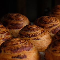 close up fresh puff pastry rolls with ham and cheese on baking pan board. A tray with fresh bakery products bread puff pastry at a local bakery. Top view