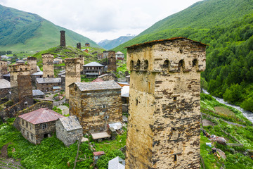 Fototapeta na wymiar View of the Ushguli village at the foot of Mt. Shkhara. Picturesque and gorgeous scene. Rock tower towers and old houses in Ushguli.