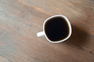 cup of coffee on wooden background. Beautiful white cup, stylish toning, place for text. Cup of black tea on wooden background. cheerful morning concept. Top view