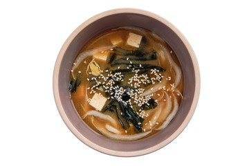 Soup with noodles, sea wed and tofu isolated on white