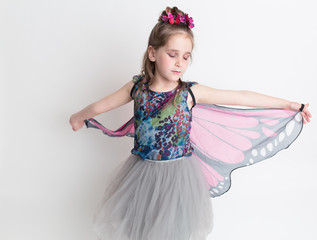 A young girl is dressed as a butterfly and ready to celebrate Halloween.
