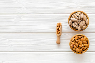 Almond in bowls for cooking on white wooden background top view mockup