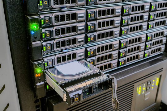 Replacing a hard drive in a powerful web server. Many disk drives are in the computer equipment of the data center. Modular repair of modern computer hardware.