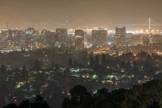 Oakland And San Francisco Cityscapes On A Hazy Summer Night. Oakland Hills, Alameda County, California, USA.