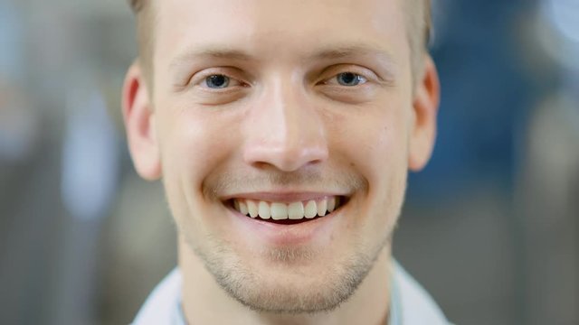 Close Up of a Handsome Young Blond Male Portrait Shot. He's a Professional Employee. Man Looks and Smiles at Camera. Expresses Success and Happiness. He Has Blue Eyes and Light Beard.