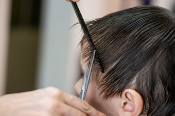 Haircut child stylist at the hairdresser