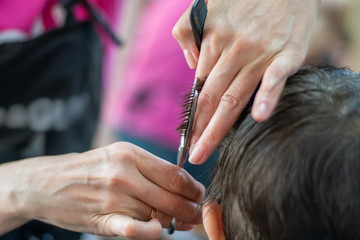 Obraz na płótnie Canvas Haircut child stylist at the hairdresser