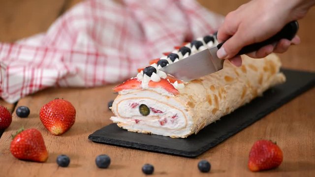 Meringue roulade decorated with blueberries and strawberries.
