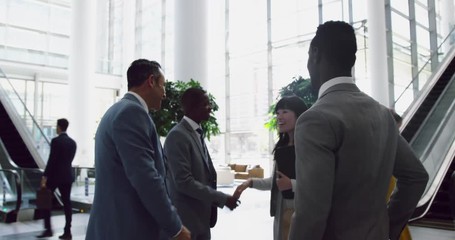 Business people interacting with each other in the lobby at office 4k - Powered by Adobe