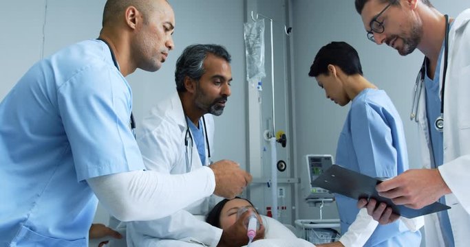 Group of doctors working together on a patient in hospital bed 4k