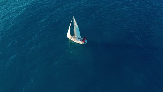 Aerial view. Yacht sailing on opened sea. Yachting with sails up at windy day.
