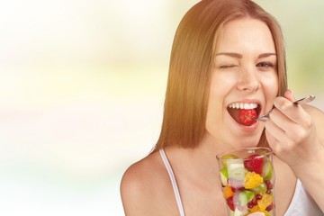 Attractive caucasian woman with fruit salad  on background