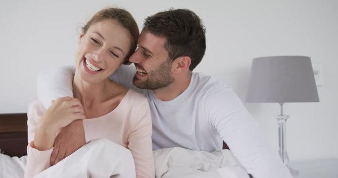 Couple sitting on bed in bedroom at comfortable home 4k