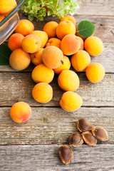 ripe apricots and seeds on a wooden table