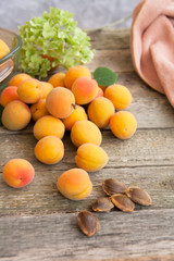 ripe apricots and seeds on a wooden table