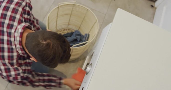 Man removing clothes in washing machine at home 4k