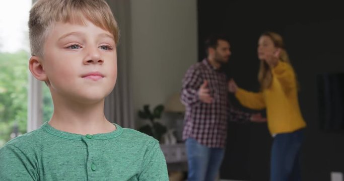 Boy standing while parents arguing with each other in the background at home 4k