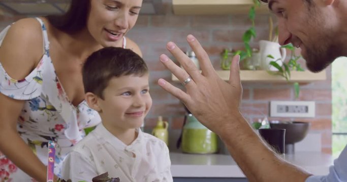 Father giving high five to his son in kitchen at home 4k