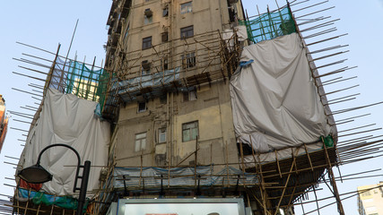 Traditional bamboo scaffolding frame at the corner of the old public building, Construction crane, bottom view, Hong Kong