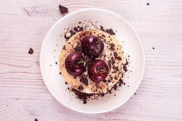 Small portion chessecake decorated with sweet cherries and chocolate.. Top view