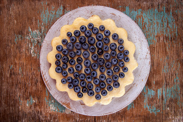 Homemade cheesecake decorated with blueberry over on fabric. Top view