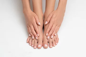 Rolgordijnen Perfect uitgevoerde manicure en pedicure op witte achtergrond. © forma82
