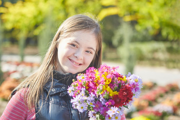 Naklejka premium Girl with Down syndrome in autumn park.