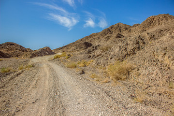 desert sand stone rocky dry scenery landscape country side wasteland environment with lonely trail 