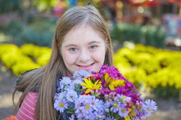 Girl with Down syndrome in autumn park.