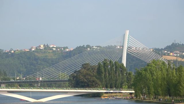 View of Mondego river with water fountain and Pedro e Ines pedestrian bridge, Coimbra, Portugal