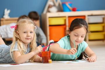 Cute little children painting in kindergarten