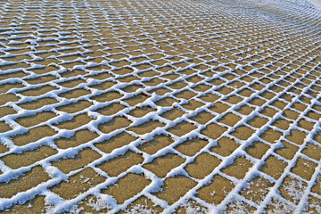 Fototapeta premium stone with grass lines under snow, winter season
