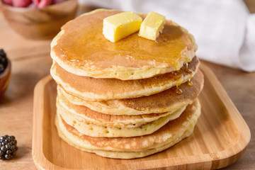 Tasty pancakes with butter on table