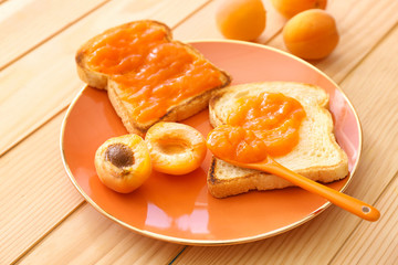 Fototapeta na wymiar Plate with tasty bread slices and jam on wooden table