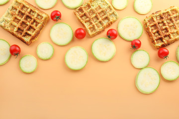 Tasty squash waffles with vegetables on color background