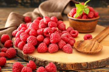 Board with fresh raspberries on wooden table